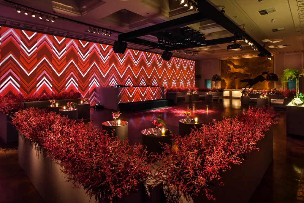 Red coral lounge with chevron projection wall