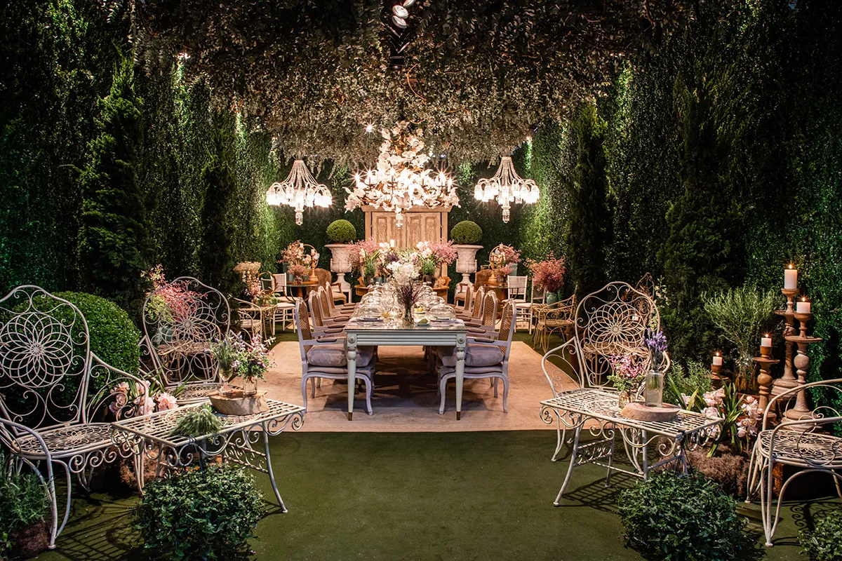 Garden setting with hedges, chandeliers and a floral table